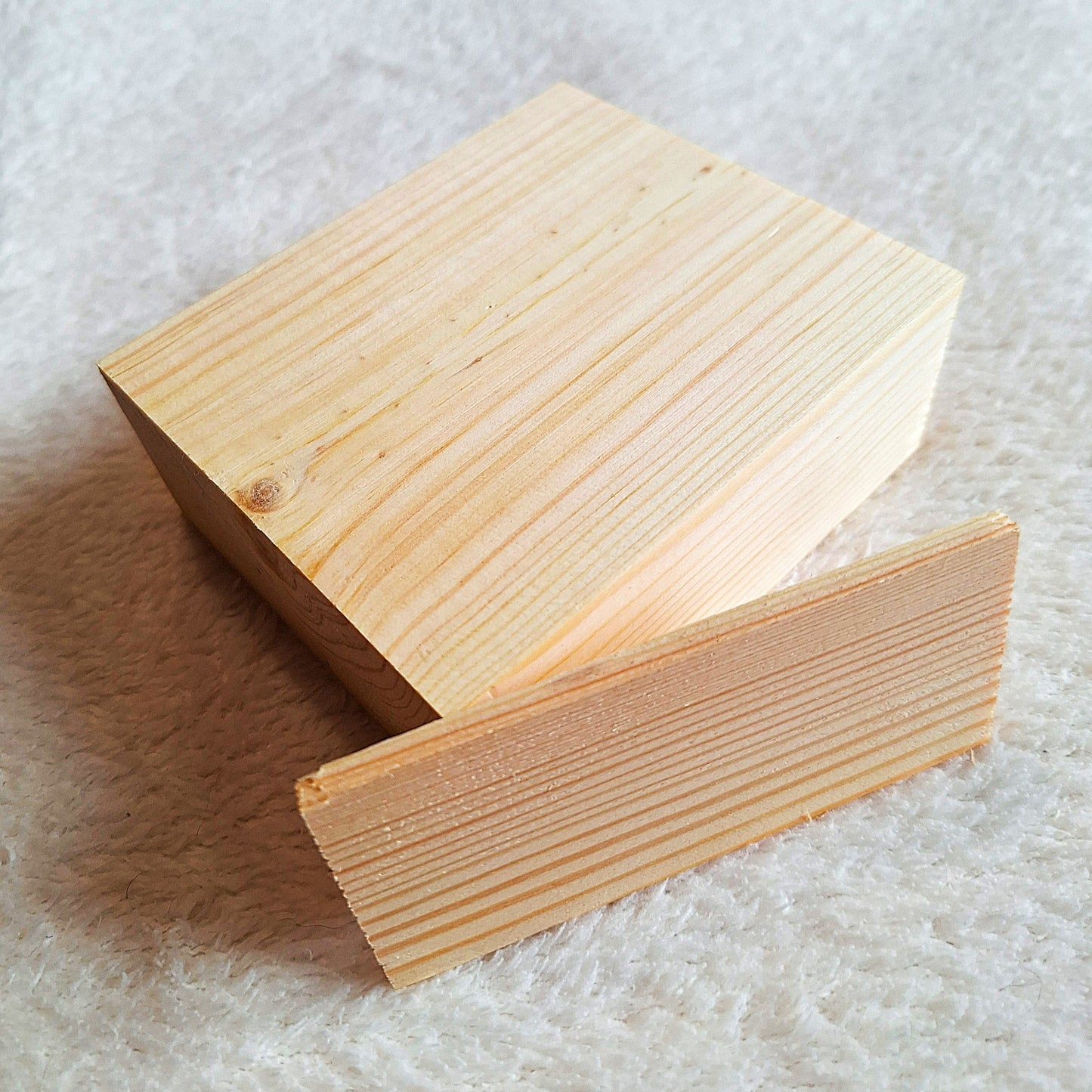 Top side oblique view of a solid pine stomp box enclosure and end plate ready to to be shaped and used in a home built project. On a white background.
