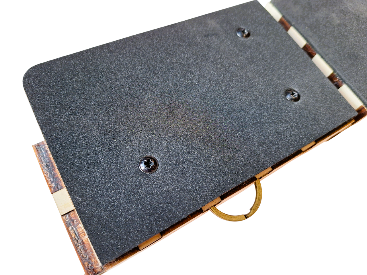 close up view of one of the rhythmic drum pads, showing neatly cut black neoprene foam covering the right hand side mini cajon box. On a white background