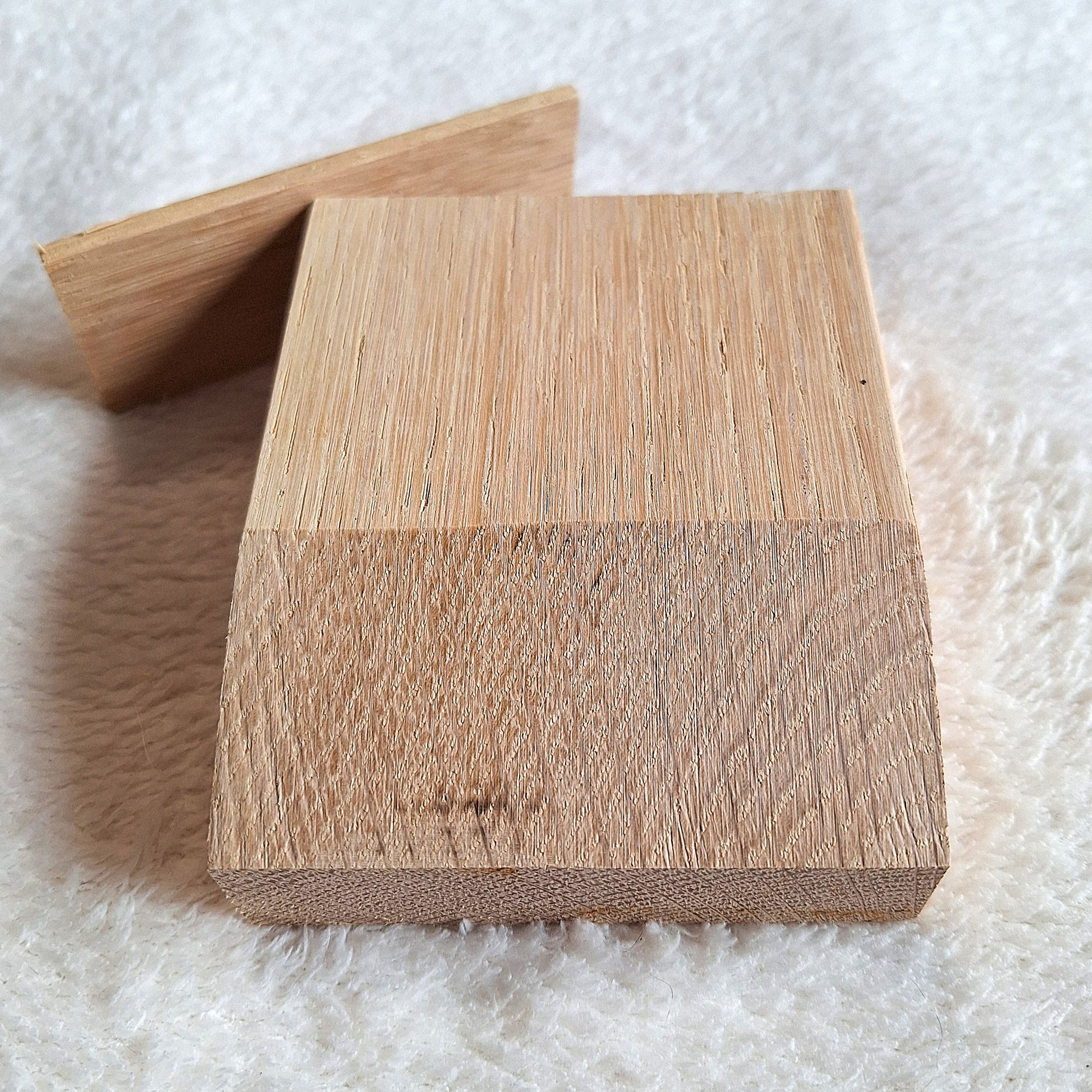 Front top view of a solid oak stomp box enclosure cut to a wedge shape with an endplate, ready to be used in a DIY build. On a white background.