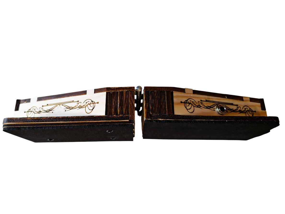 Opened bottom view of  'The Rhythmic' described as two laser-cut and etched pine boxes, each with a contoured bottom edge. this view shows a quarter-inch audio output jack and steam punk inspired scroll graphics. On a transparent background
