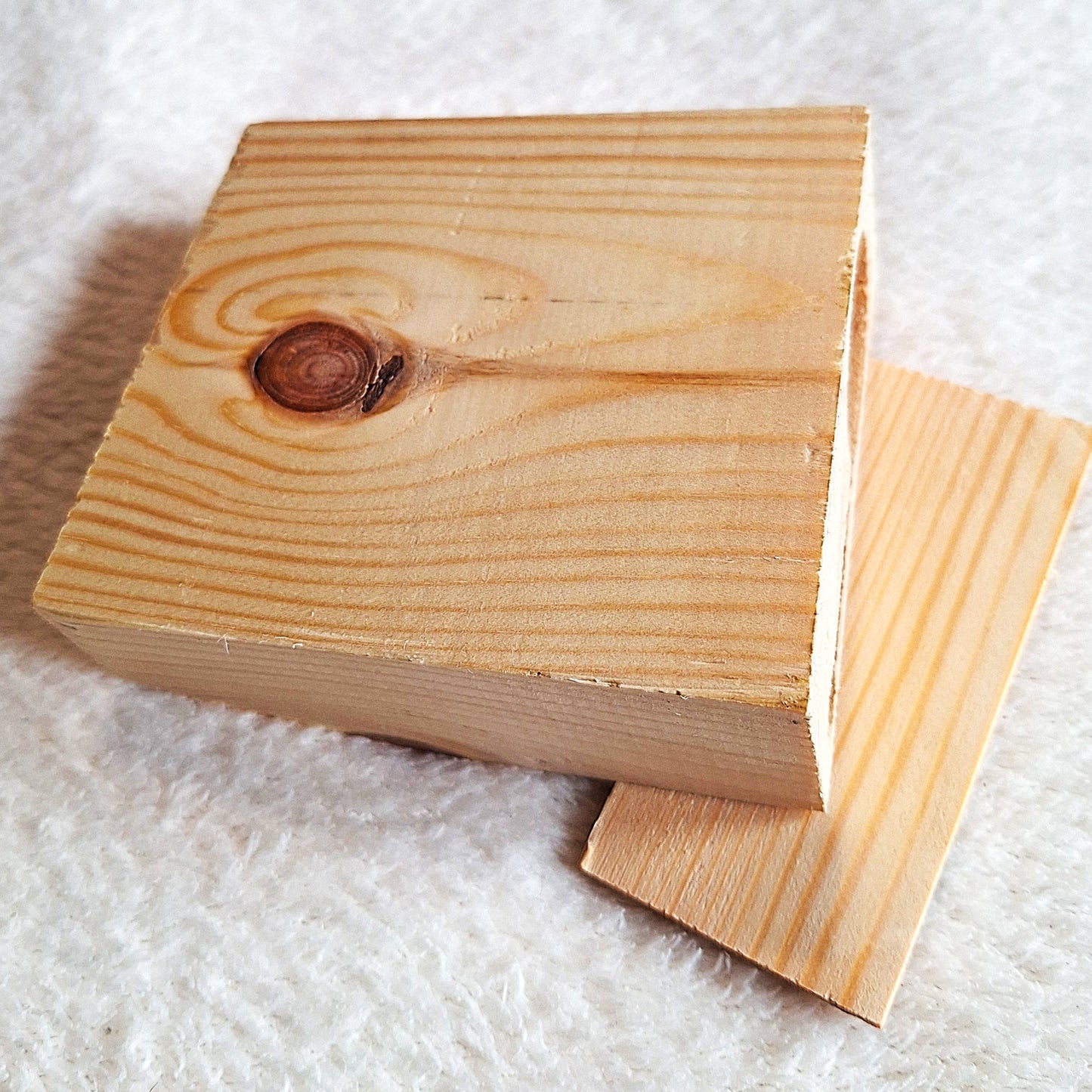 Underside view of a solid oak stomp box enclosure cut to a wedge shape and showing a matching endplate, ready to to be used in a home built build. On a white background.