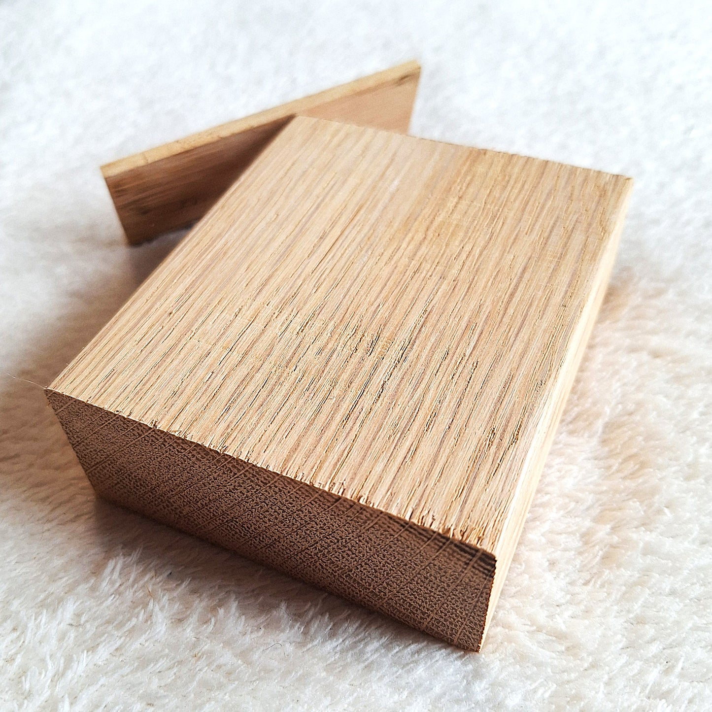 Top rear oblique view of a solid oak stomp box enclosure and end plate ready to to be shaped and used in a home built project. On a white background.