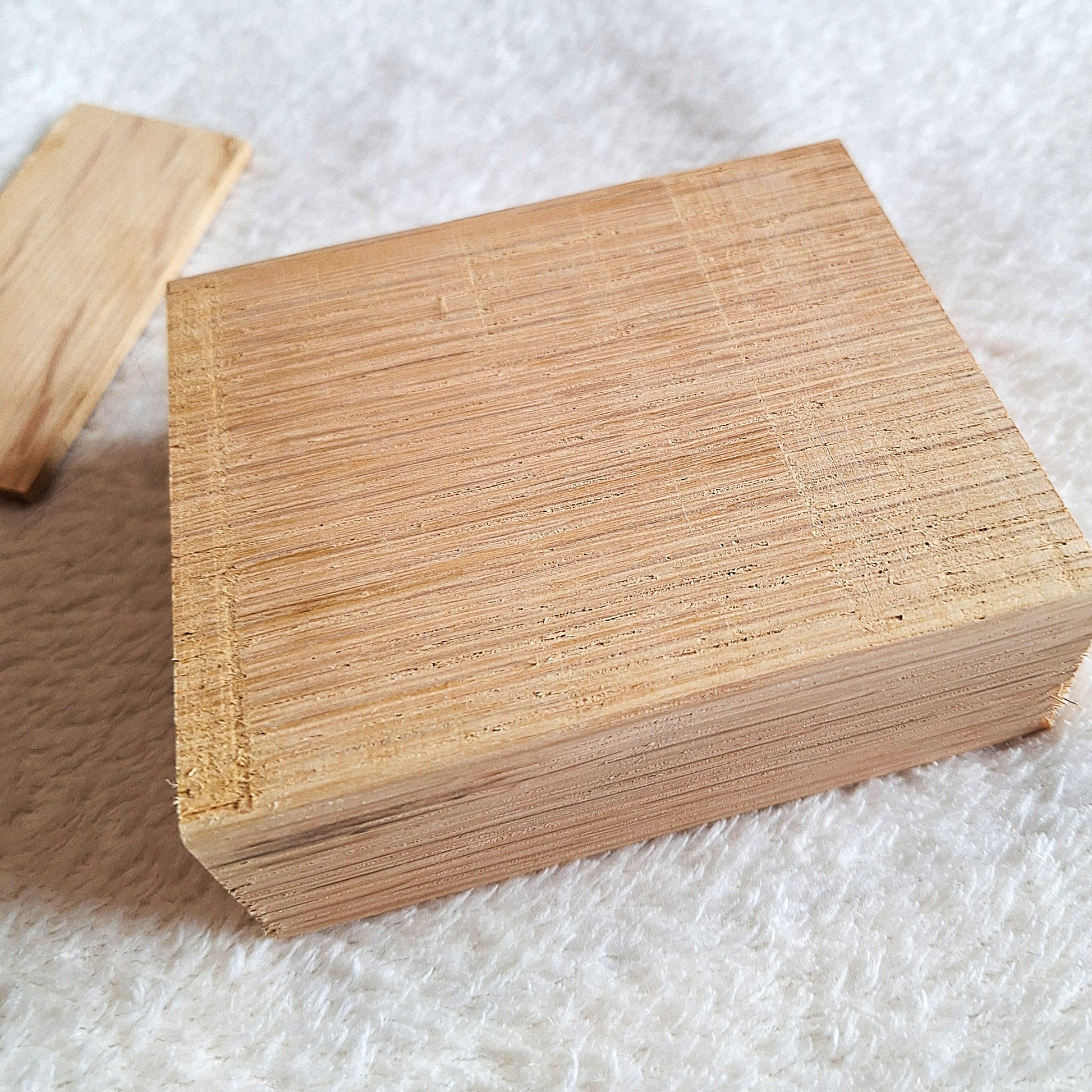 Top side oblique view of a solid oak stomp box enclosure and end plate ready to to be shaped and used in a home built project. On a white background.