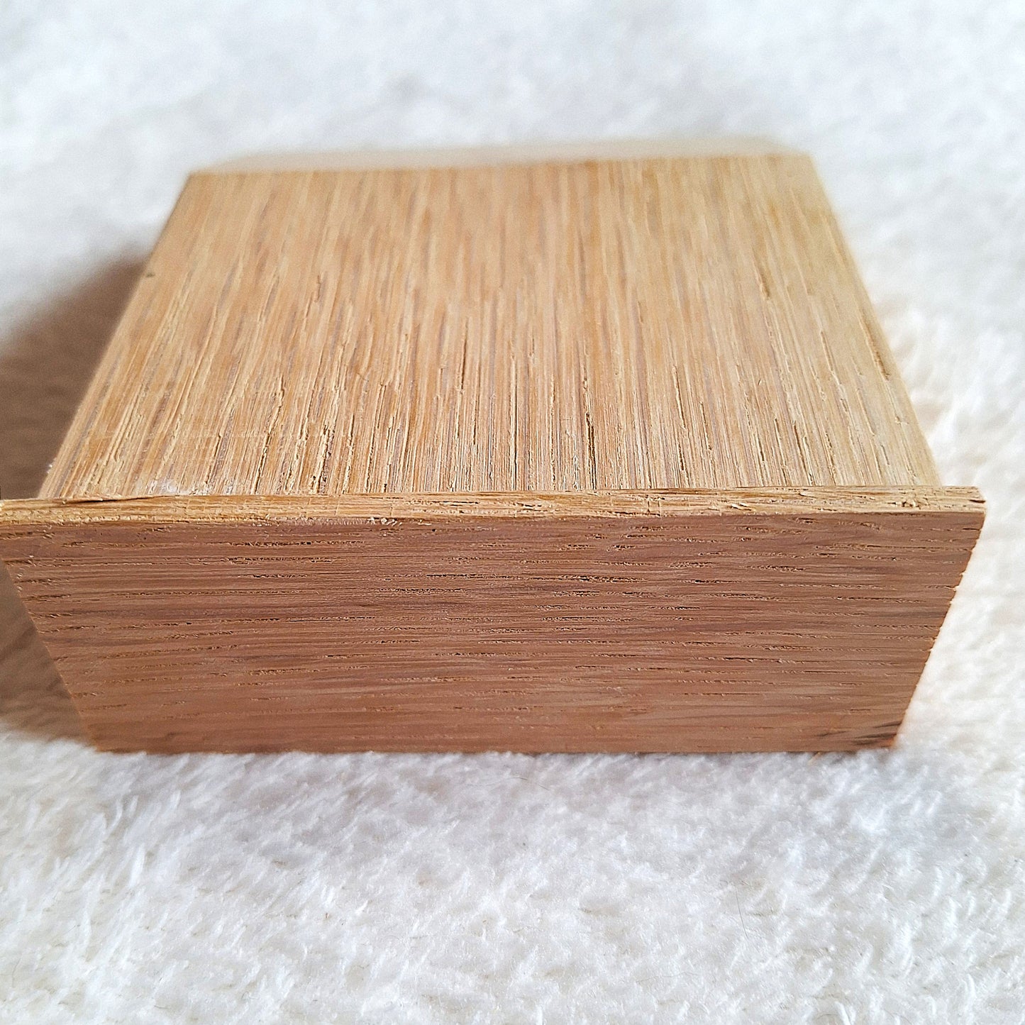 Top rear view of a solid oak stomp box enclosure cut to a wedge shape and showing a matching endplate, ready to to be used in a DIY build. On a white background.