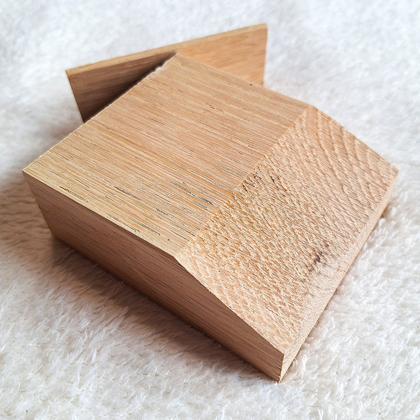 Top oblique view of a solid oak stomp box enclosure cut to a wedge shape and showing a matching endplate, ready to to be used in a DIY build. On a white background.
