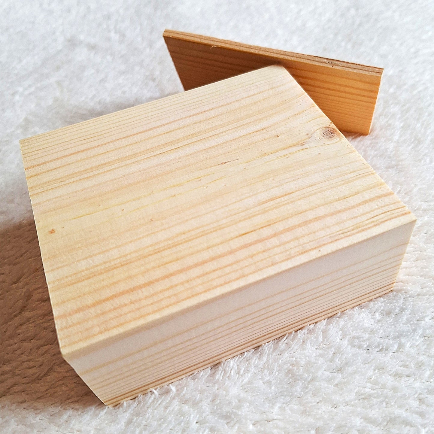 Side oblique view of a solid pine stomp box enclosure and end plate ready to to be shaped and used in a home built project. On a white background.