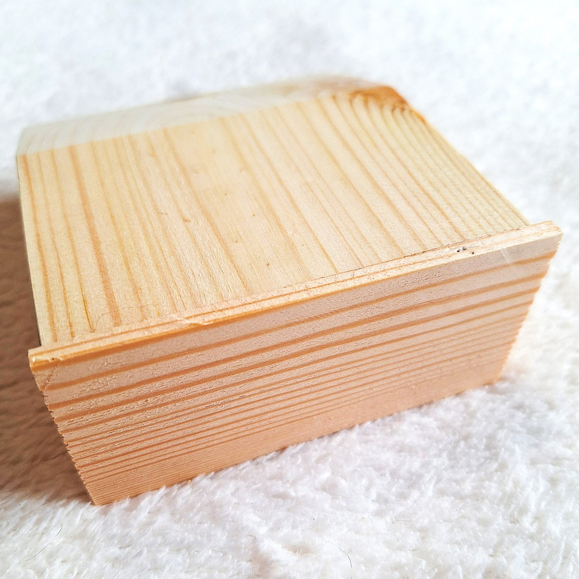 Rear oblique view of a solid pine stomp box enclosure cut to a wedge shape and showing a matching endplate, ready to to be used in a home built build. On a white background.