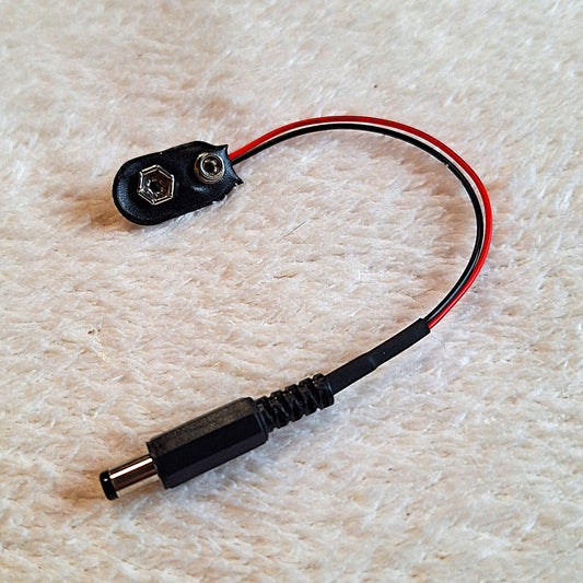 close view of a guitar effect pedal power jack with approx 10cm of wire and a 9v battery connector