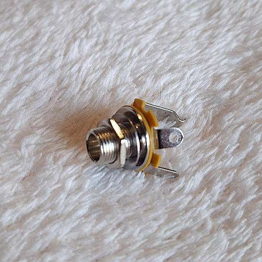 close up of a metal quarter inch 1/4" mono audio jack featuring washer and retaining scew.