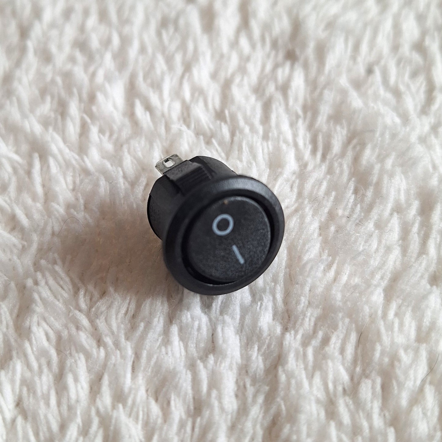 Close up of a small on / off toggle switch on a white background.