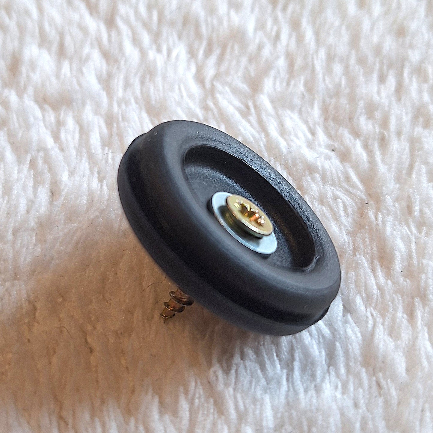 oblique view of a singular 30mm round rubber foot featuring a washer and a screw protruding through the middle.